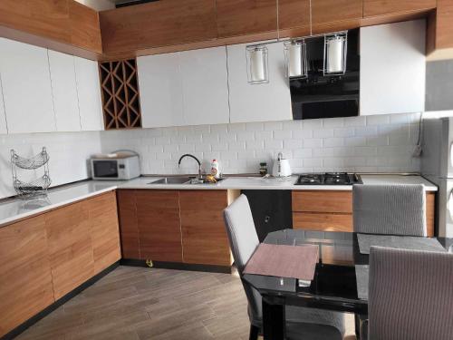 une cuisine avec des placards blancs et une table avec des chaises dans l'établissement HOME, à Tbilissi