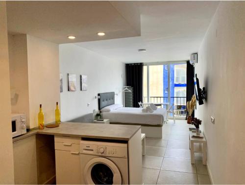 uma cozinha e sala de estar com uma cama e uma máquina de lavar roupa em Inviting Studio with Sea View em Torremolinos