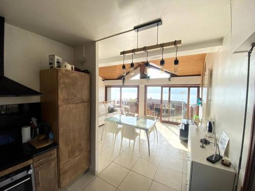 une cuisine avec une table et une salle à manger dans l'établissement Duplex avec jardin, superbe vue lac, Veyrier, à Veyrier-du-Lac