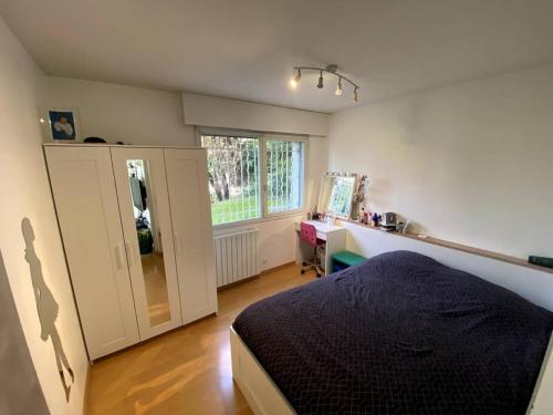 une chambre avec un lit, un bureau et une fenêtre dans l'établissement Duplex avec jardin, superbe vue lac, Veyrier, à Veyrier-du-Lac