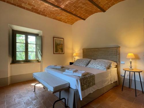 een slaapkamer met een groot bed en een raam bij Podere Montaione in Volterra