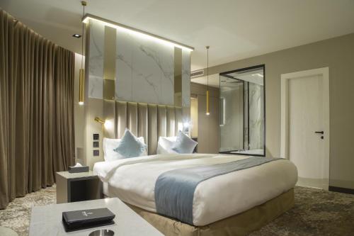 a hotel room with a large bed and a mirror at فندق راسيا المدينة المنورة in Al Madinah
