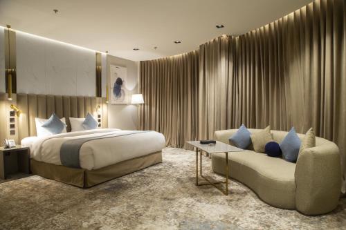 Habitación de hotel con cama y sofá en فندق راسيا المدينة المنورة en Medina