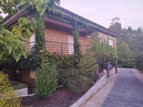 a building with ivy growing on the side of it at Casa Campo ao Rio_Village in Barcelos