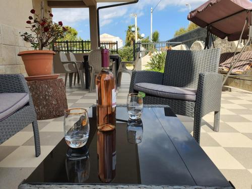 una botella de vino sentada en una mesa con dos copas en Villa Tellina Mare Luna, en Granelli