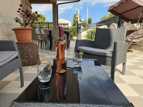 a bottle of wine sitting on a table with two glasses at Villa Tellina Mare Luna in Granelli