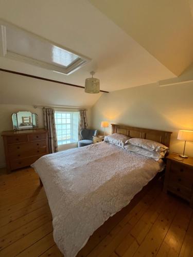 a bedroom with a large bed and a window at Slieve Donard Cottage Widows Row cottages in Newcastle