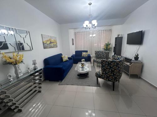 a living room with a blue couch and chairs at Paramount 3-Bedroom Apartment with Parking in San Felipe de Puerto Plata