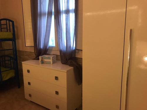 a room with a dresser and a window with curtains at Villa Tellina Mare Luna in Granelli