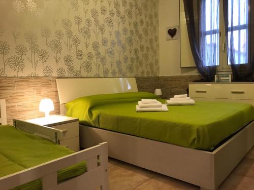 グラネッリにあるVilla Tellina Mare Lunaのベッドルーム(緑のシーツを使用したベッド2台付)