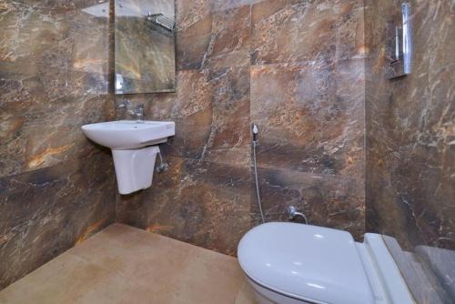 een badkamer met een toilet en een wastafel bij Hotel Kabeer By A1Rooms in New Delhi