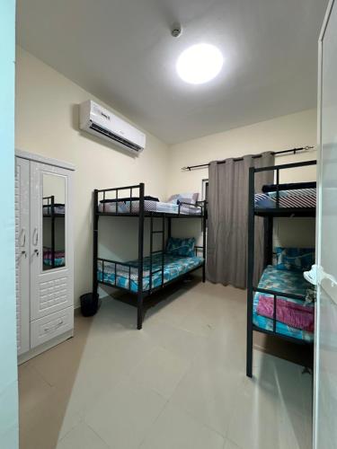 a room with three bunk beds in a room at Palm Inn Hostel 2024 in Dubai