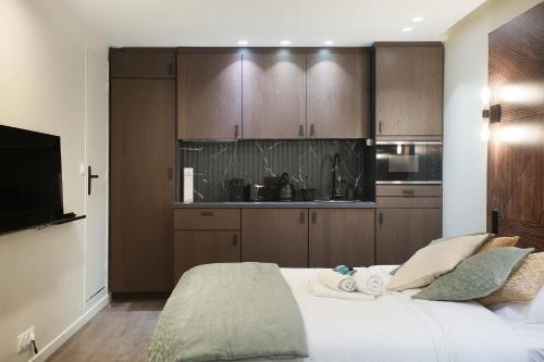 - une chambre avec un lit blanc et des placards en bois dans l'établissement Studio Sacré coeur by Studio prestige, à Paris