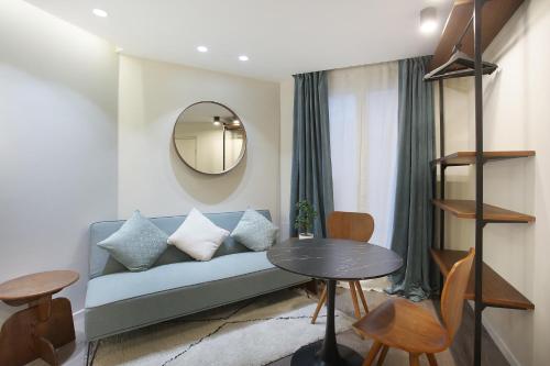 un salon avec un canapé bleu et une table dans l'établissement Studio Sacré coeur by Studio prestige, à Paris