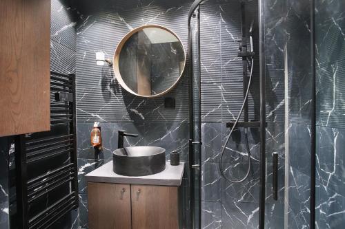 une salle de bain avec un lavabo et un miroir dans l'établissement Studio Sacré coeur by Studio prestige, à Paris