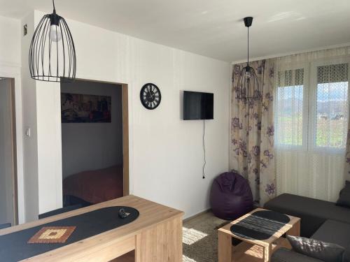 uma sala de estar com um sofá e uma mesa em Apartmani Urošević em Vrhpolje