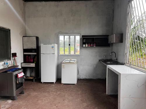 a kitchen with two white refrigerators and a window at Residência Shalom in Presidente Figueiredo