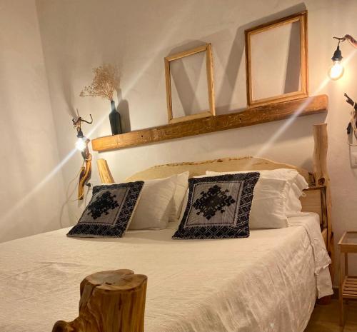 una camera con un letto con due cuscini di I Ginepri a Teulada