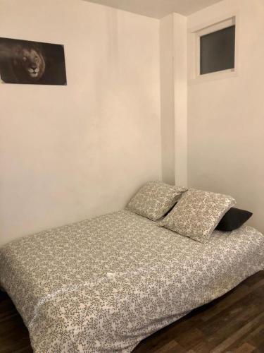 uma cama com duas almofadas num quarto em Studio lumineux et équipé em Villemomble