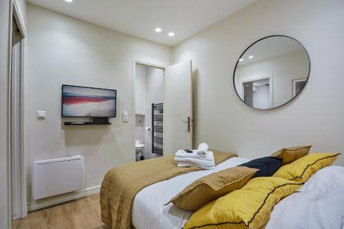 une chambre avec un grand lit et un miroir dans l'établissement Apartment Sacré coeur by Studio prestige, à Paris