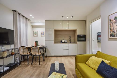 un salon avec un canapé jaune et une cuisine dans l'établissement Apartment Sacré coeur by Studio prestige, à Paris