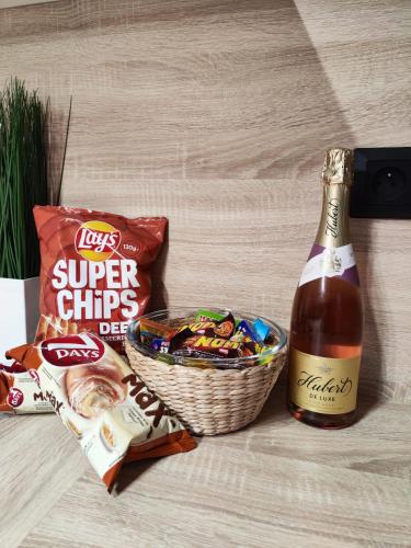 a bottle of beer and a basket of snacks at Nový Exkluzívny 2 izbový apartmán Rajpark Residence Rajecké Teplice in Rajecké Teplice