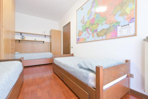 a room with two beds and a map on the wall at Queen Home Paola in Favaro Veneto