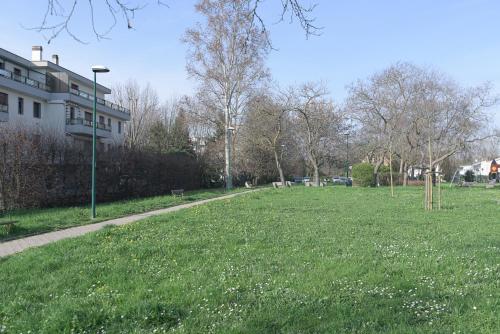 a field of grass with a building and a street light at Queen Home Paola in Favaro Veneto