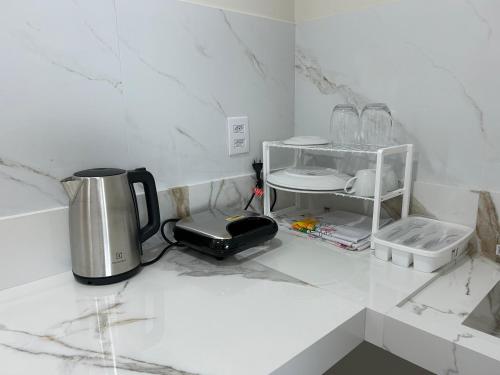 eine Theke mit einem Toaster und einer Kaffeemaschine darauf in der Unterkunft Loft Solaris Apart Hotel - Suíte - Apt. N.105 in João Câmara