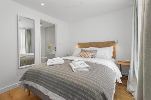 a bedroom with a bed with two towels on it at City Escape with a Touch of Class in Eastbourne