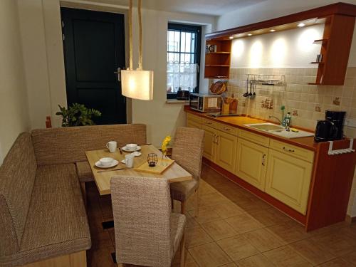 cocina con mesa, sillas y fregadero en Apartment Am Markt 4, en Bad Gottleuba