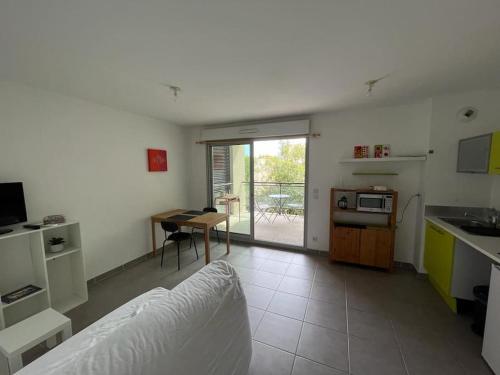 - une cuisine avec un canapé et une table dans une chambre dans l'établissement Joli T2 avec terrasse au calme, à Montpellier