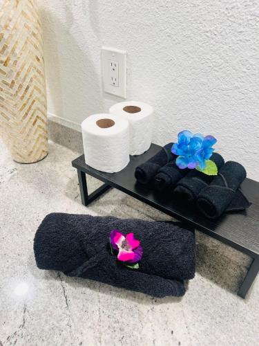 a table with towels and rolls of toilet paper and flowers at Trendy Midtown Apartment in Houston