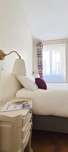 une chambre avec deux lits et une lampe et une fenêtre dans l'établissement 2 pièces calme à 300m du château, à Versailles