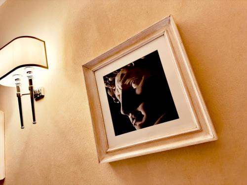 a picture hanging on a wall next to a lamp at Relais Uffizi in Florence