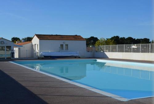 une piscine avec de l'eau bleue devant une maison dans l'établissement La Villa Bleu 300 m de la Mer, à Bretignolles-sur-Mer