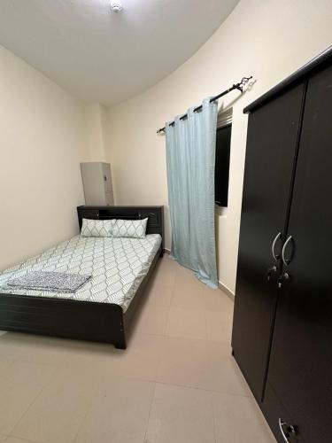 sypialnia z łóżkiem i czarną szafką w obiekcie Palm Inn Hostel w Dubaju