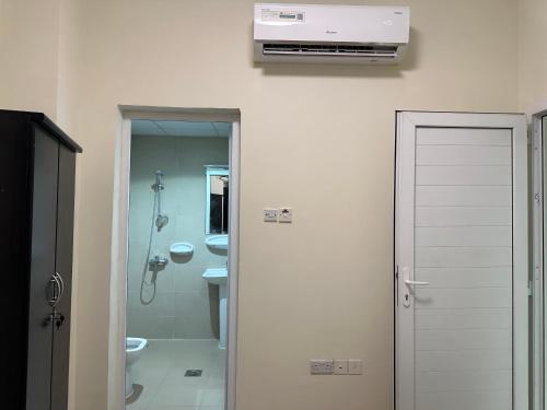 a bathroom with a shower and a toilet and a heater at Palm Inn Hostel in Dubai