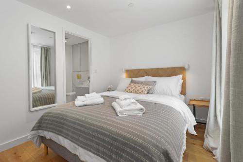ein Schlafzimmer mit einem Bett mit zwei Handtüchern darauf in der Unterkunft Sleek and Serene Your Modern Haven in Eastbourne in Eastbourne