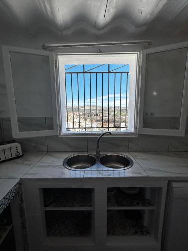 a kitchen counter with a sink and a window at The Crystal Cave in Zújar