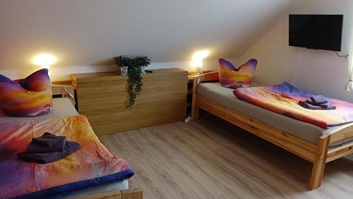a room with two beds and a flat screen tv at Ferienwohnung Schwedt Kastanienhöfe in Schwedt