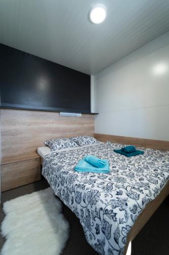 a bedroom with a bed with blue shoes on it at Mobile home Mariola in Sveti Petar