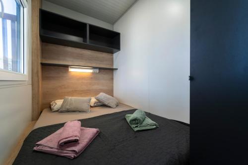 a bedroom with a bed with two towels on it at Mobile home Mariola in Sveti Petar