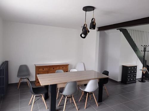 une salle à manger avec une table et des chaises en bois dans l'établissement Maison de vacances Morbihan, à Landaul