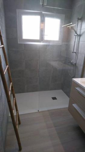 une salle de bain avec une douche avec une porte vitrée dans l'établissement Maison de vacances Morbihan, à Landaul