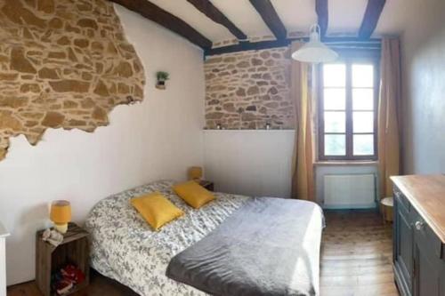 une chambre avec un lit et un mur en pierre dans l'établissement Maison Vacances 12 pers / Périgord Noir / Piscine, à Saint-Julien-de-Lampon