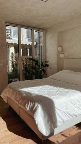 a large bed in a bedroom with a large window at Atrium Apartments Aachen in Aachen