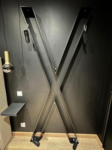 un mur métallique avec une porte en verre dans une pièce dans l'établissement Dark Room BLOIS - Love Room, à Saint-Gervais-la-Forêt