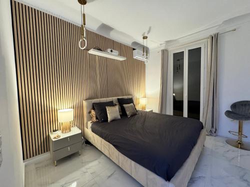 ein Schlafzimmer mit einem Bett und einem Beistelltisch mit Lampen in der Unterkunft Appartement vue mer vue Monaco in Beausoleil