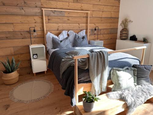 a bedroom with a bed with a wooden wall at Apartmány Zahražany in Most